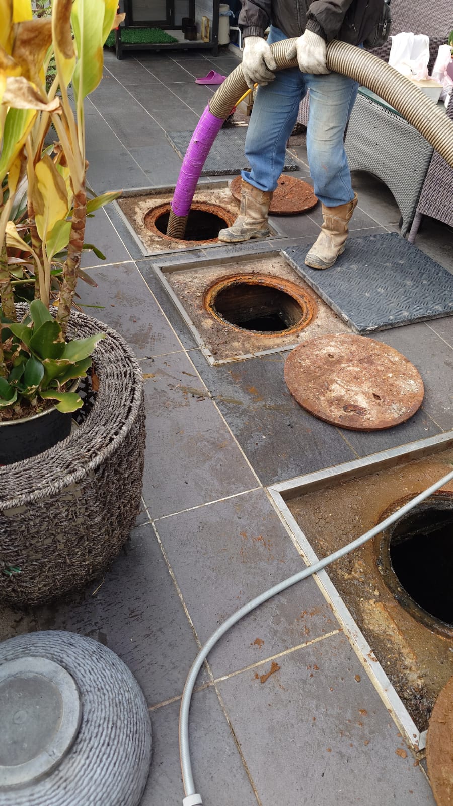 Technician operating a suction hose to pump a septic tank